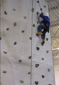climbing Someone climbing on a climbing wall in a gym