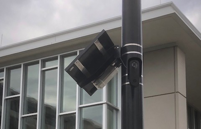 A license plate reader next to a university building.