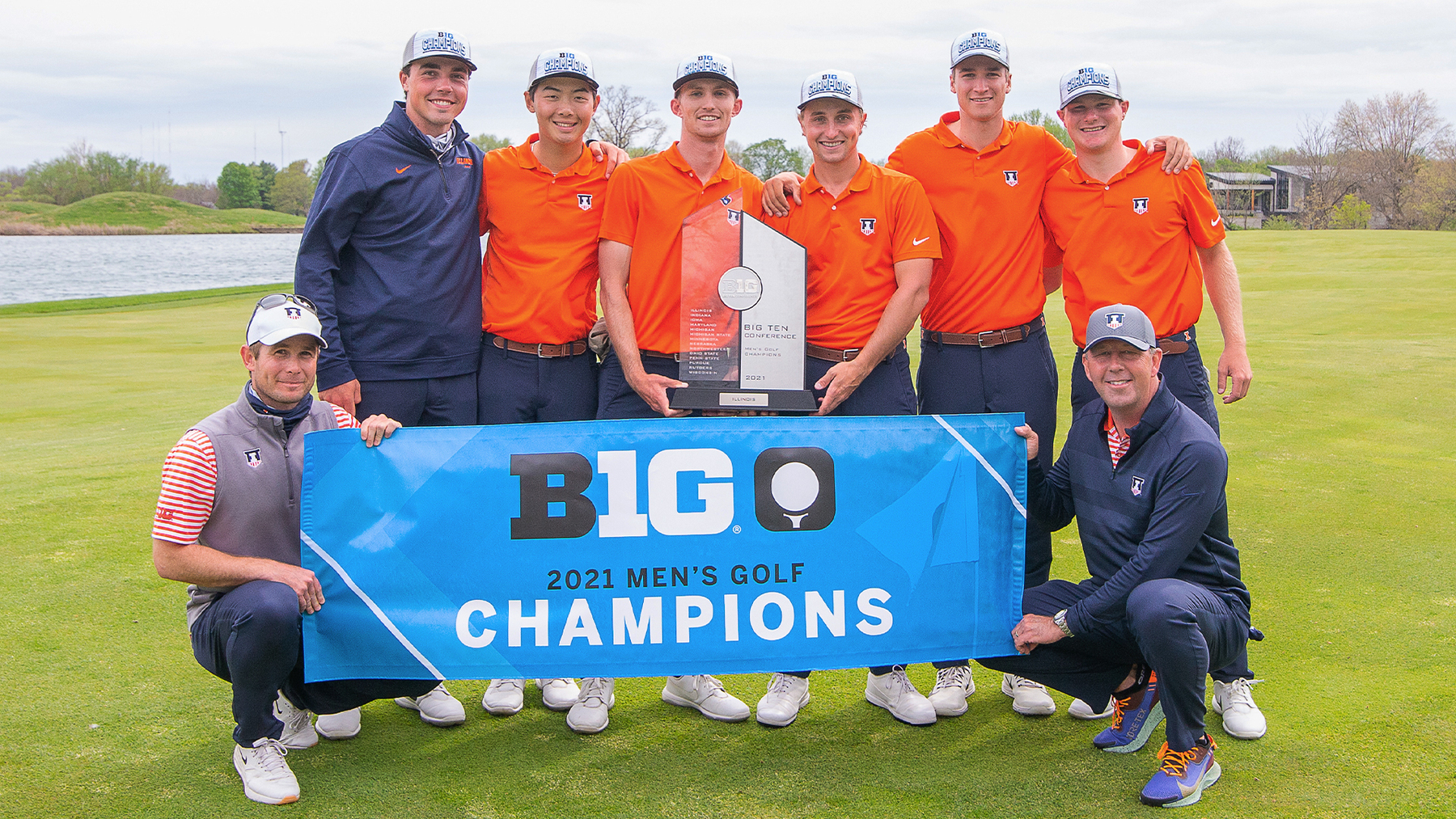 Coaches and team members hold a Big Ten Title banner