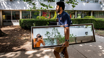 A wayward mirror catches University of Illinois photographer Fred Zwicky at work covering student move-in. Photo by Fred, of course.