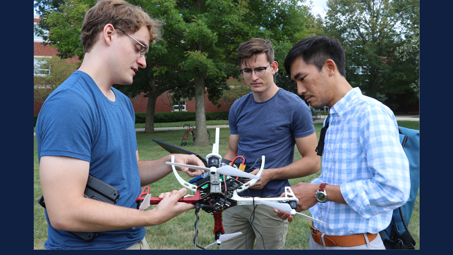 Neale Van Stralen, Ayberk Yaraneri, and Huy Tran test a drone on the U of I campus. (2019)