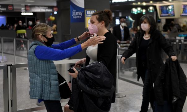 Family members embrace each other as they are reunited upon arrival on a flight from Amsterdam as the US reopens air and land borders to vaccinated travellers for the first time since the COVID-19 restrictions were imposed, at Dulles International Airport in Chantilly, Virginia on November 8, 2021. (Photo by OLIVIER DOULIERY/AFP via Getty Images)