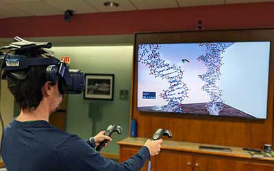 a visitor explores a virtual reality exhibit to interact with DNA at the Beckman Institute Open House