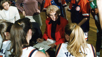 Huddled with players, Coach Grentz charts a play in this file photo.
