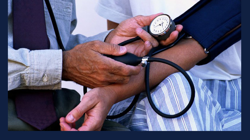 brown-skinned arm has blood pressure checked. Image via Wikimedia Commons