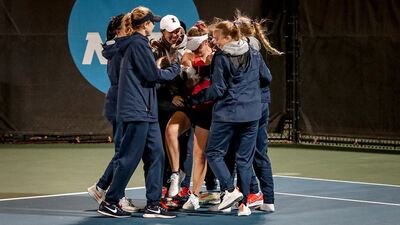 Illini tennis players celebrate around freshman Kasia Treiber after she secured the team victory