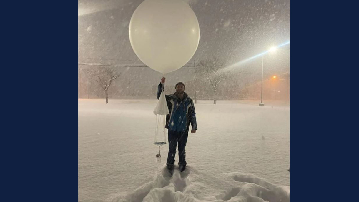 Andrew Janiszeski prepares to launch a weather balloon near Geneseo on a previous deployment for IMPACTS. Hanging below the weather balloon is the radiosonde, which will collect data as the balloon rises and then parachute back down once the balloon pops.