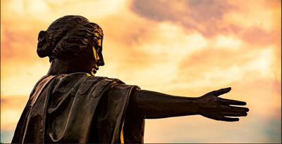 Alma Mater statue in golden light of sunset. Photo by Fred Zwicky