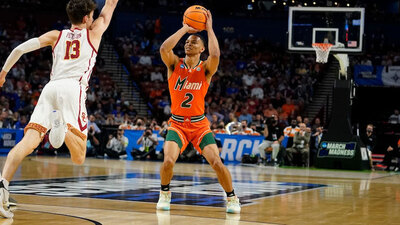Miami’s Isaiah Wong (2) shoots and scores during the first half of a college basketball game in the first round of the NCAA tournament against Southern California’s Drew Peterson (13) March 18, 2022, in Greenville, S.C. An agent for Wong, a prominent college athlete finally said out loud what schools likely hear in private: Pay the player more, or he will transfer to a school that will. The demand made on behalf of Wong provided a rare glimpse into the way elite college sports have been transformed by student-athletes’ rights to earn money through endorsements. (AP Photo/Brynn Anderson, File)