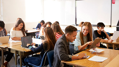 stock image of high school students using tablets and laptops in class