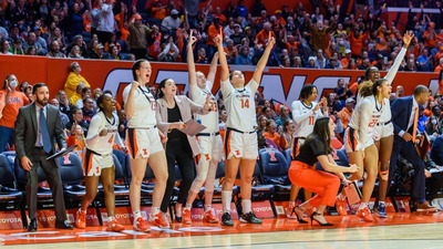 Coaches and players on the sideline celebrate a three point shot in the new year's day victory over 12th ranked Iowa