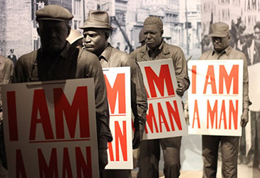image of sculptures of men, each carrying 'i am a man' sign