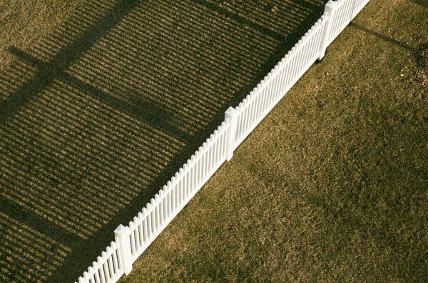 Gallery Stock image by Gary Adolfsson shows a picket fence separating two lawns, one covered in sunlight, the other in shadows