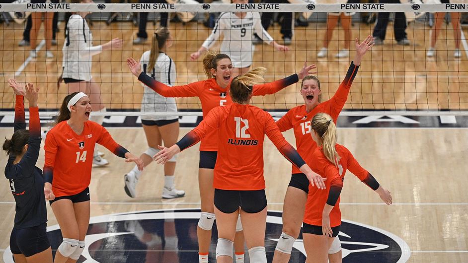 Illini volleyball players celebrate on Penn State's court
