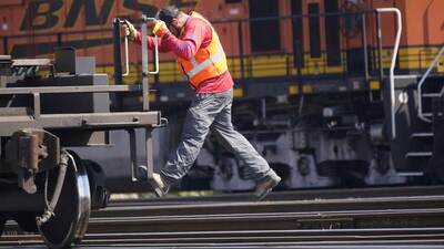 A worker rides a rail car at a BNSF rail crossing in Saginaw, Texas, Wednesday, Sept. 14, 2022.  (AP Photo/LM Otero)
