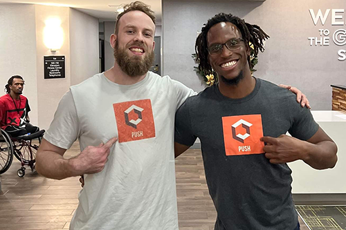 Derek Hoot and Martinez Johnson point to the "Push Podcast" logos on their shirts. (submitted photo)