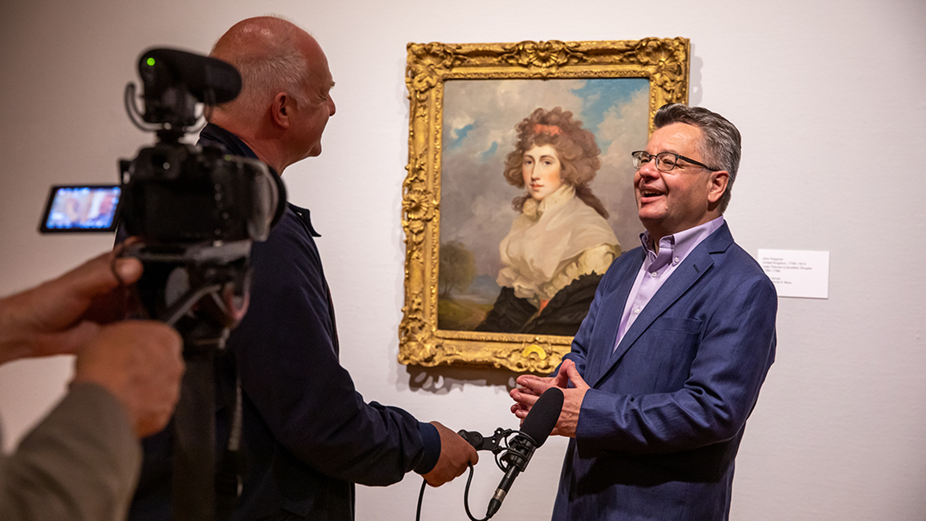 History professor Craig Koslofsky is interviewed beside a painting at the Krannert Art Museum by a German film crew. Photo by Michelle Hassel