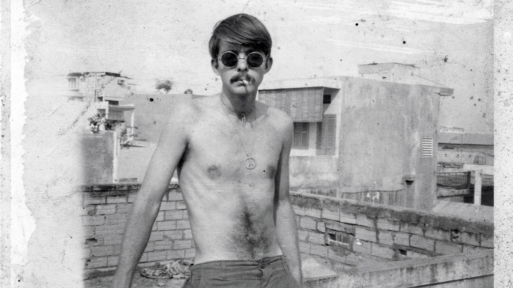 black and white image of Jimmy, shirtless, in Saigon. Courtesy of Peter McDowell