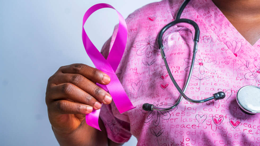 Nurse in pink smock hold pink ribbon. Image by Yah Niel via Shutterstock