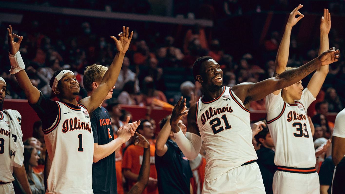 Trent Frazier, Kofi Cockburn, Coleman Hawkins and other Illini players celebrate a three point shot on the sidelines during a recent game