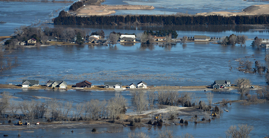 Homes in Nebraska are surrounded by floodwater last year. The Trump administration is delaying work on the National Climate Assessment. SrA Jamie Titus/UPI/Newscom