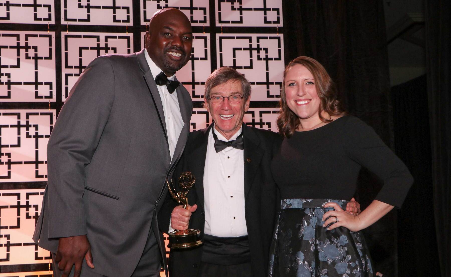 Nathaniel "Big Easy" Lofton, recently retired from the Harlem Globetrotters, presents the Emmy Award to U of I producers Tim Hartin and Kaitlin Southworth.