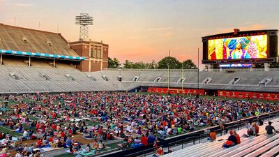 fans watch a movie from the field at Memorial Stadium at a past FamILLy Night