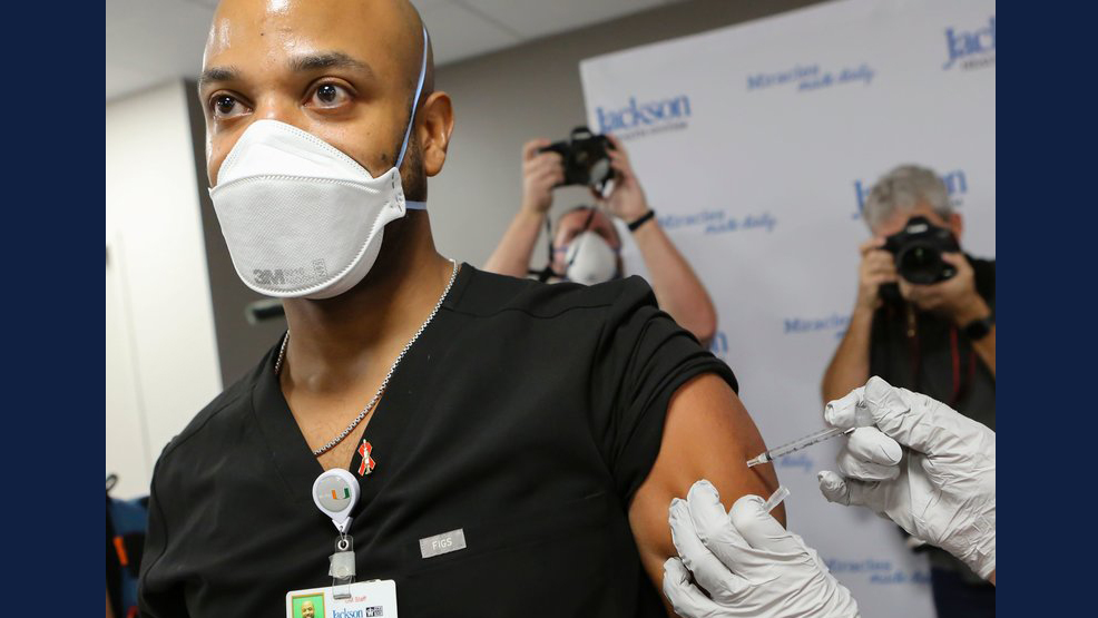 Dr. Hansel Tookes made sure his first dose of Pfizer's COVID-19 vaccine at Jackson Memorial Hospital in Miami on Dec. 15. was televised, as a way to combat hesitancy. Eva Marie Uzcategui/AFP via Getty Images