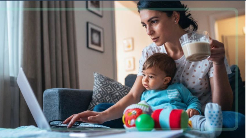 mother works on laptop at home with baby on her lap. filadendron/Getty Images