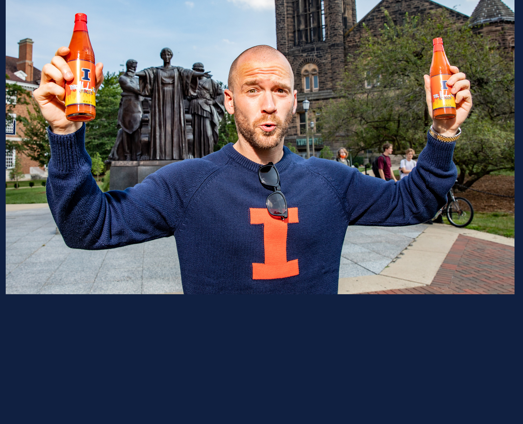 Sean Evans, alumnus of the College of Media and host of the YouTube show, 'Hot Ones, stands at the Alma Mater statue