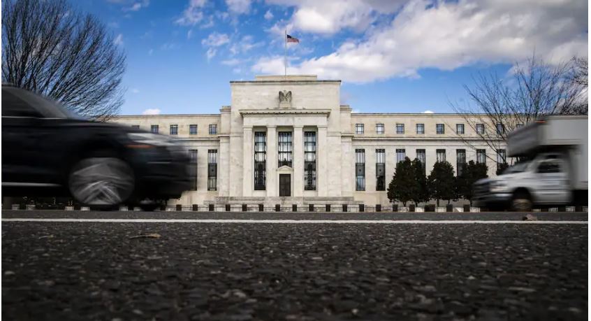 Vehicles pass in front of the Marriner S. Eccles Federal Reserve Board Building in Washington on Jan. 22. (Al Drago/Bloomberg)