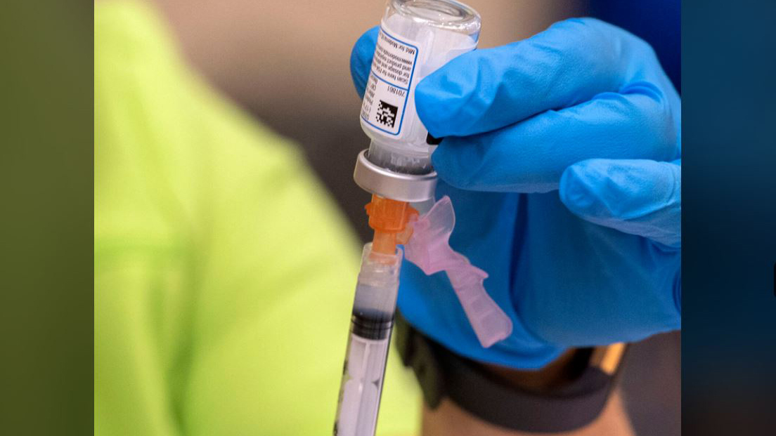 nurse draws Pfizer vaccine into a syringe