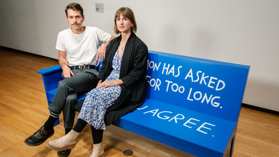 Artist Christopher Robert Jones, who teaches in the School of Art and Design, and exhibition curator Liza Sylvestre, Krannert Art Museum’s curator of academic programs, sit on a bench that is part of the 'Crip*' exhibition.