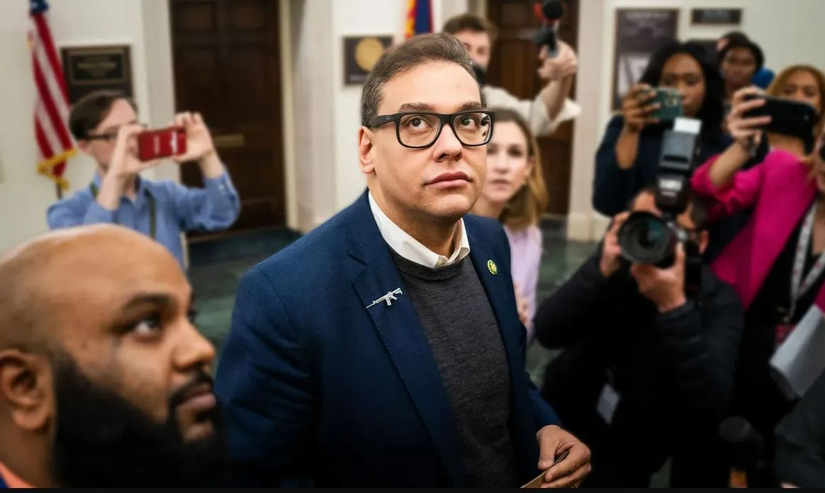 Reporters surround embattled Rep. George Santos (R-NY) as he heads to the House Chamber for a vote wearing an assault rifle pin. (Kent Nishimura / Los Angeles Times via Getty Images)