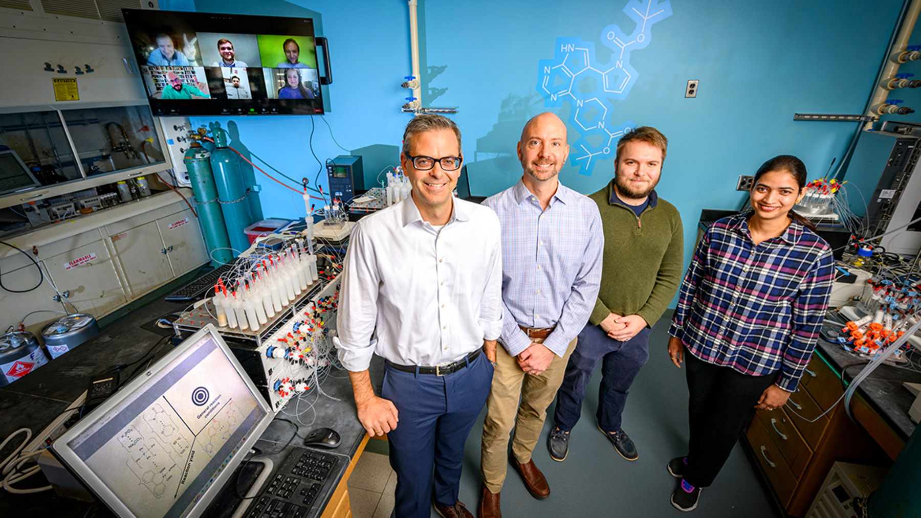 University of Illinois chemistry professor Martin D. Burke, materials science and engineering professor Charles M. Schroeder, graduate student Nicholas Angello and postdoctoral researcher Vandana Rathore. Shown in a lab. hHoto by Fred Zwicky