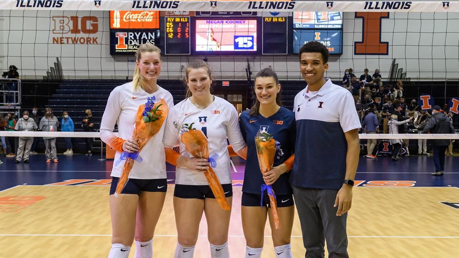 seniors pose at the net holding bouquets of flowers