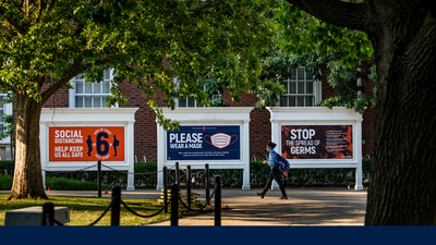 signs outside the Illini Union display safety messages - wear a mask, socially distance, wash your hands
