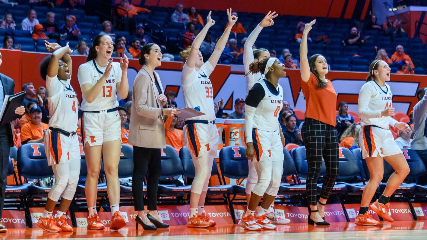 players and coaches cheer from the sidelines during a previous Illini Women's Basketball game at State Farm Center