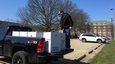 Conner Weber, a student at Illinois, unloads boxes for a food drive inspired in part by a history class on the Great Depression. Photo courtesy of Leslie Reagan.