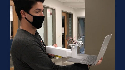 Bioengineering student Benjamin Salzberg demonstrates the prototype of the EYES ultrasonic scanning device