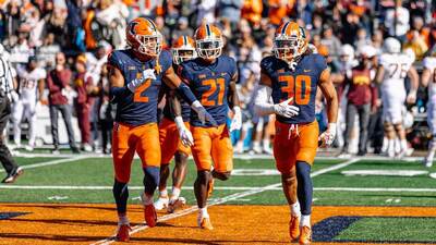Illinois defensive players trot off the field smiling after a stop