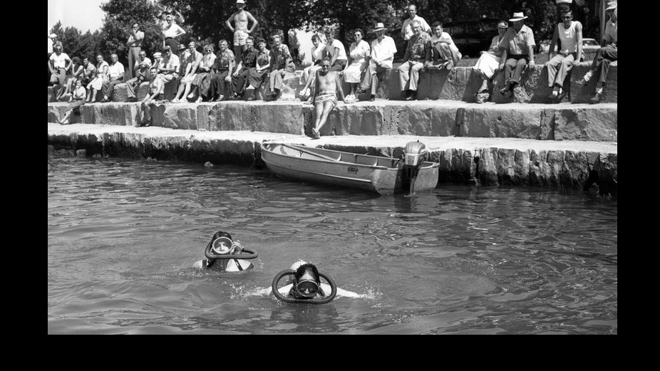 Volunteer divers Robert Domkowski, left, and Chuck Napravnik, right, search Lake Michigan for three missing bodies at Montrose Harbor after a meteotsunami hit the lakefront on June 26, 1954. (Chicago Tribune historical photo)