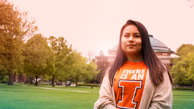 student on the Quad; Foellinger Auditorium background