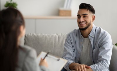 stock image of young man speaking with a counselor
