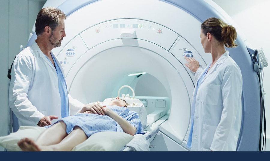stock image shows medical personnel preparing to slide a patient into an MRI mechine. Photo via Getty Images