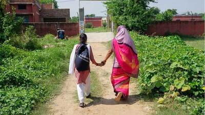 image from the SwaTaleem organization appears to show a woman and girl walking toward (presumably) a school.