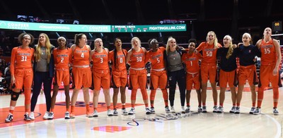 Women's Basketball team with coaches, all arm-in-arm