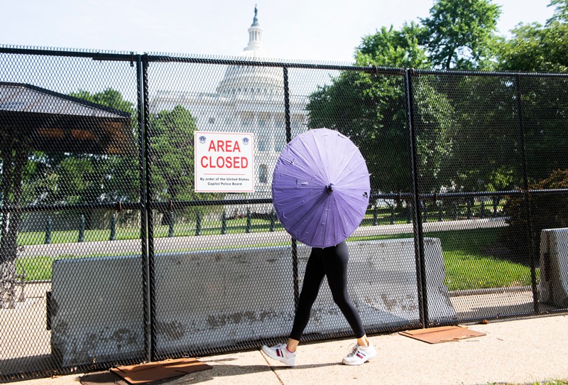 woman uses a parasol while walking in extreme heat in Washington, D.C. Credit: Tom Williams/CQ-Roll Call/Getty