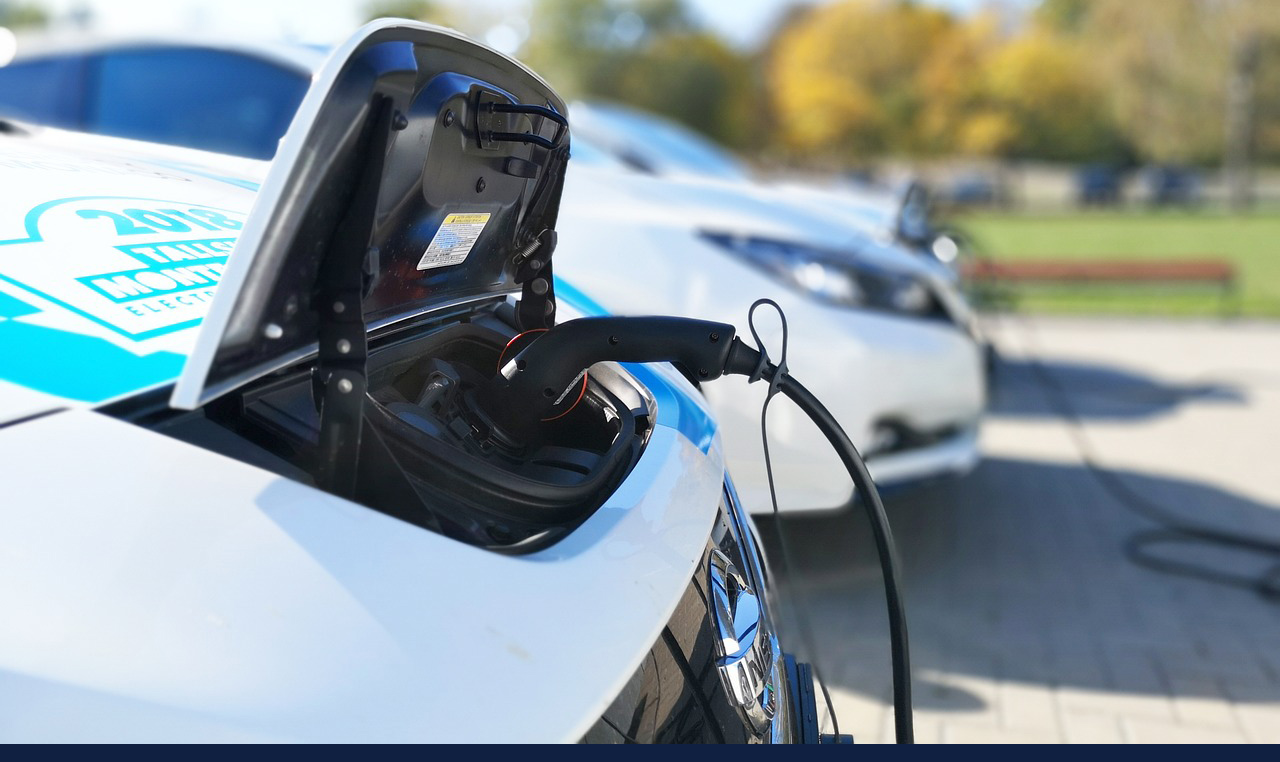 stock image of an electric vehicle at a charging station. Photo via Pixabay