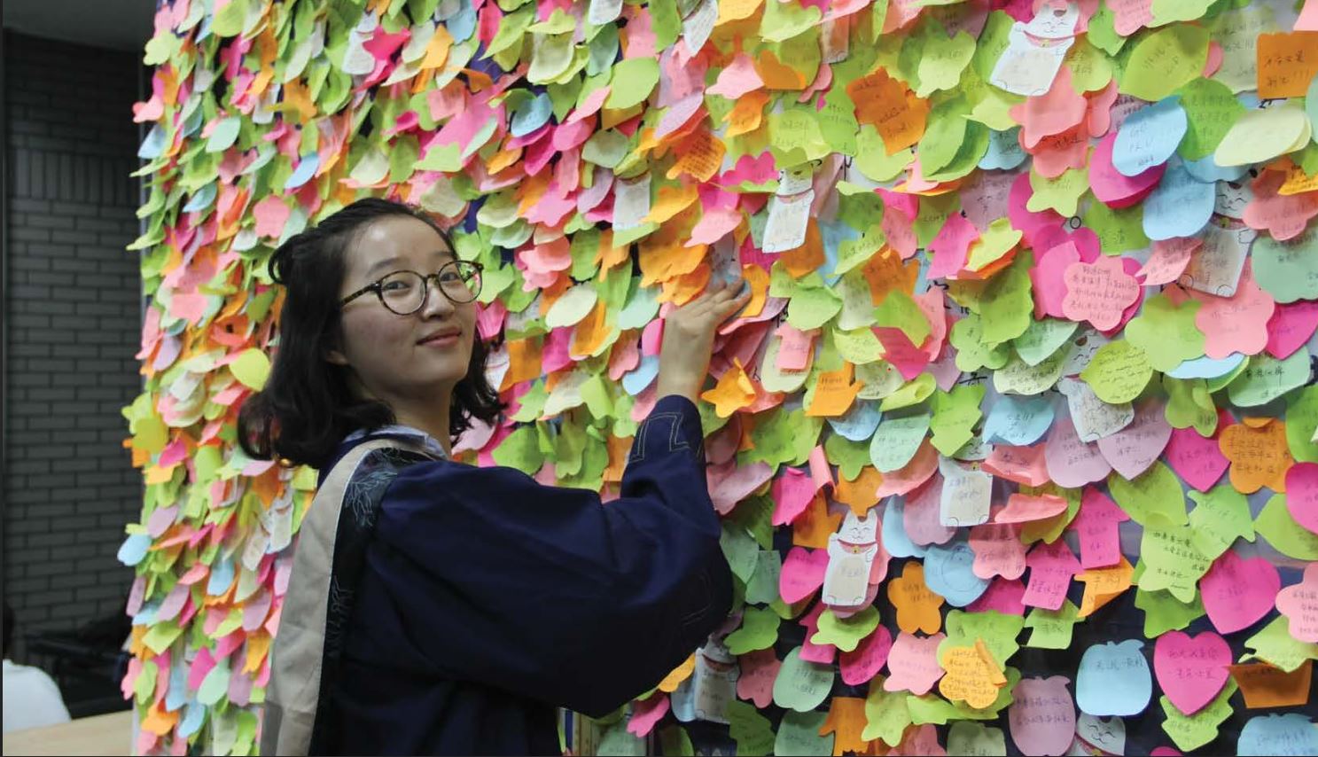 YingYing Zhang at a board covered with post-it notes